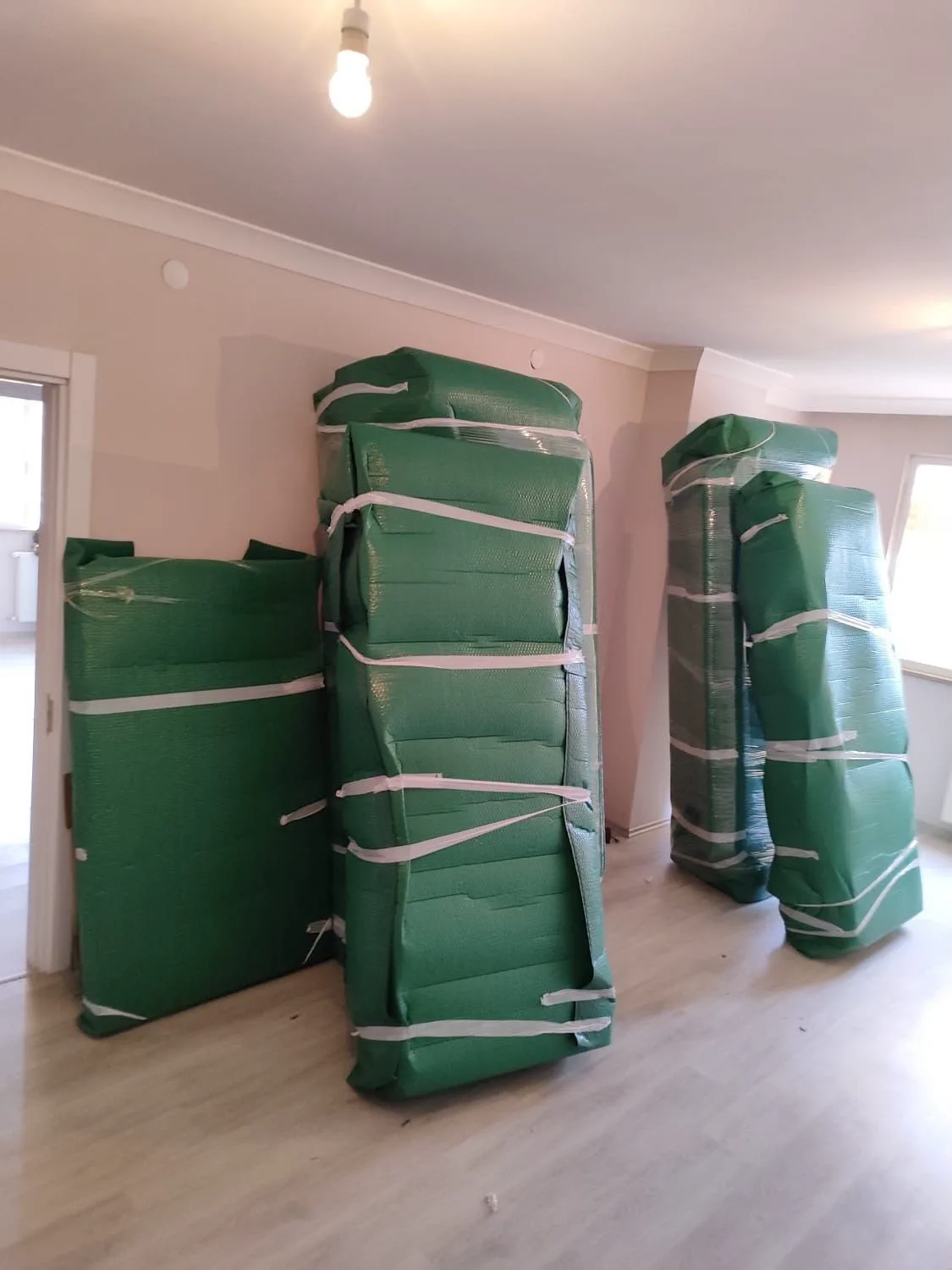Taşınma öncesi odada gruplandırılarak koruyucu battaniyeyle paketlenen eşyalar